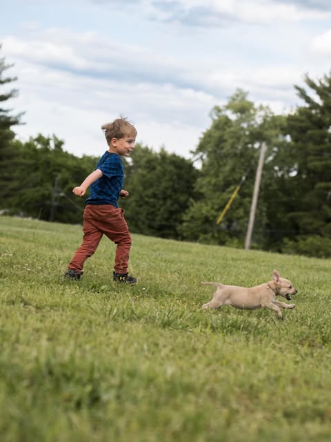 Atom running across the grass with his puppy