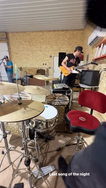 A drum kit facing a guitarist during the last song of the night