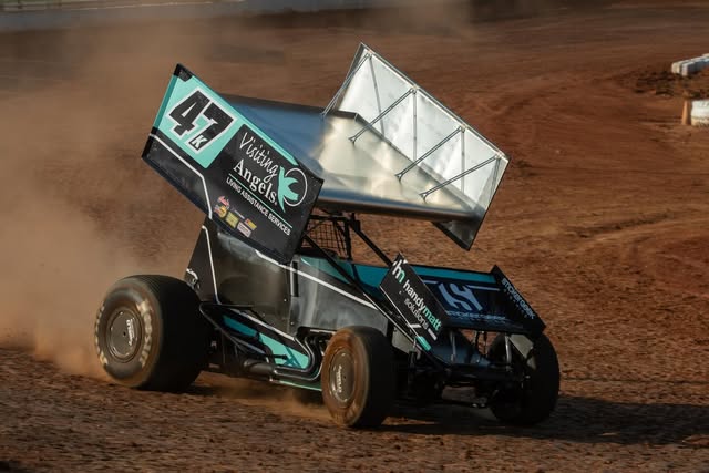 Winged sprint car number 47 racing on a dirt track